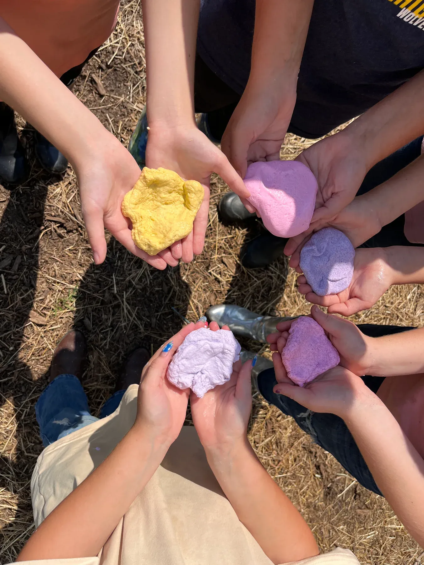 Campers holding colorful creations during an outdoor camp activity